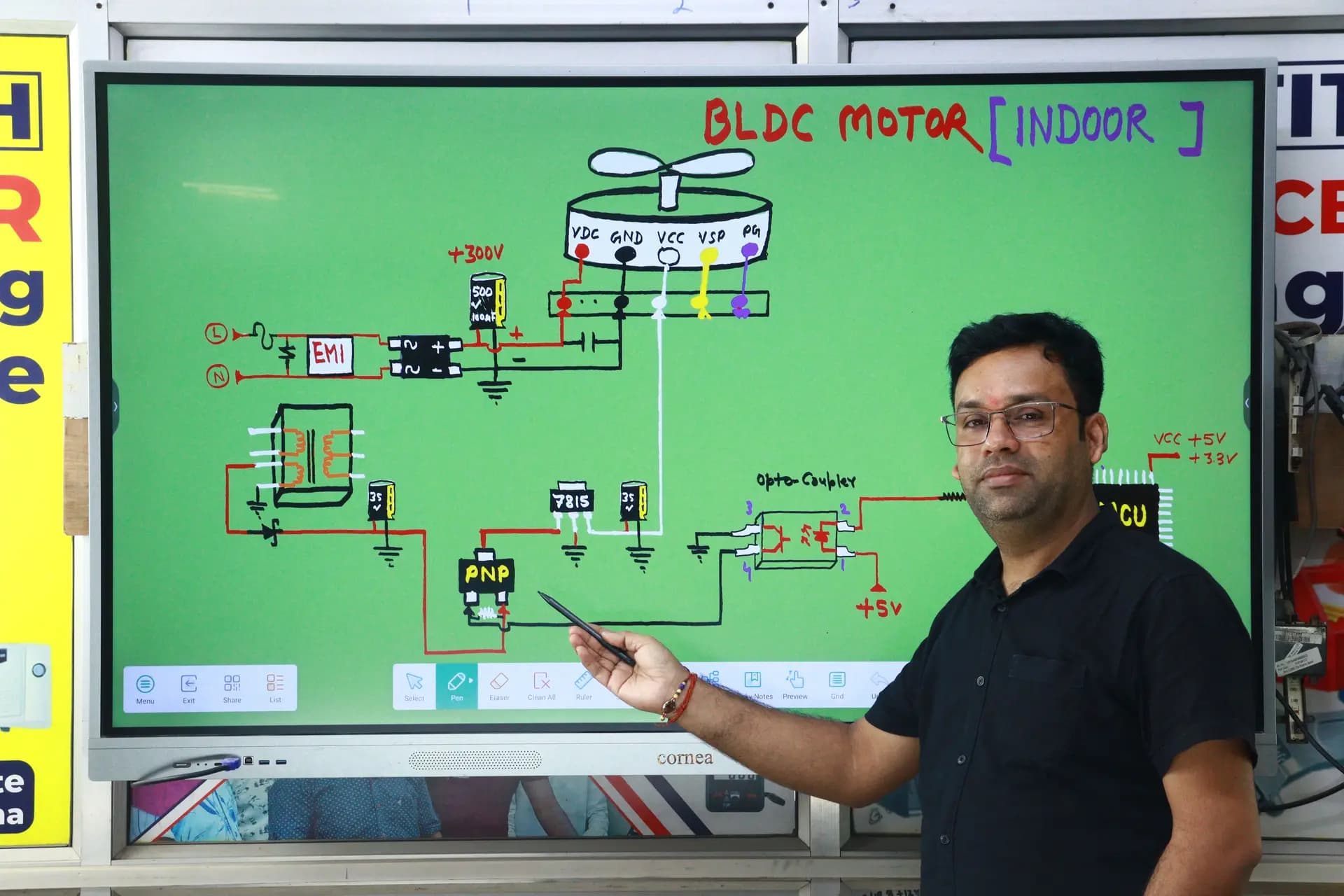 Instructor pointing at a large board showing a BLDC motor control circuit diagram