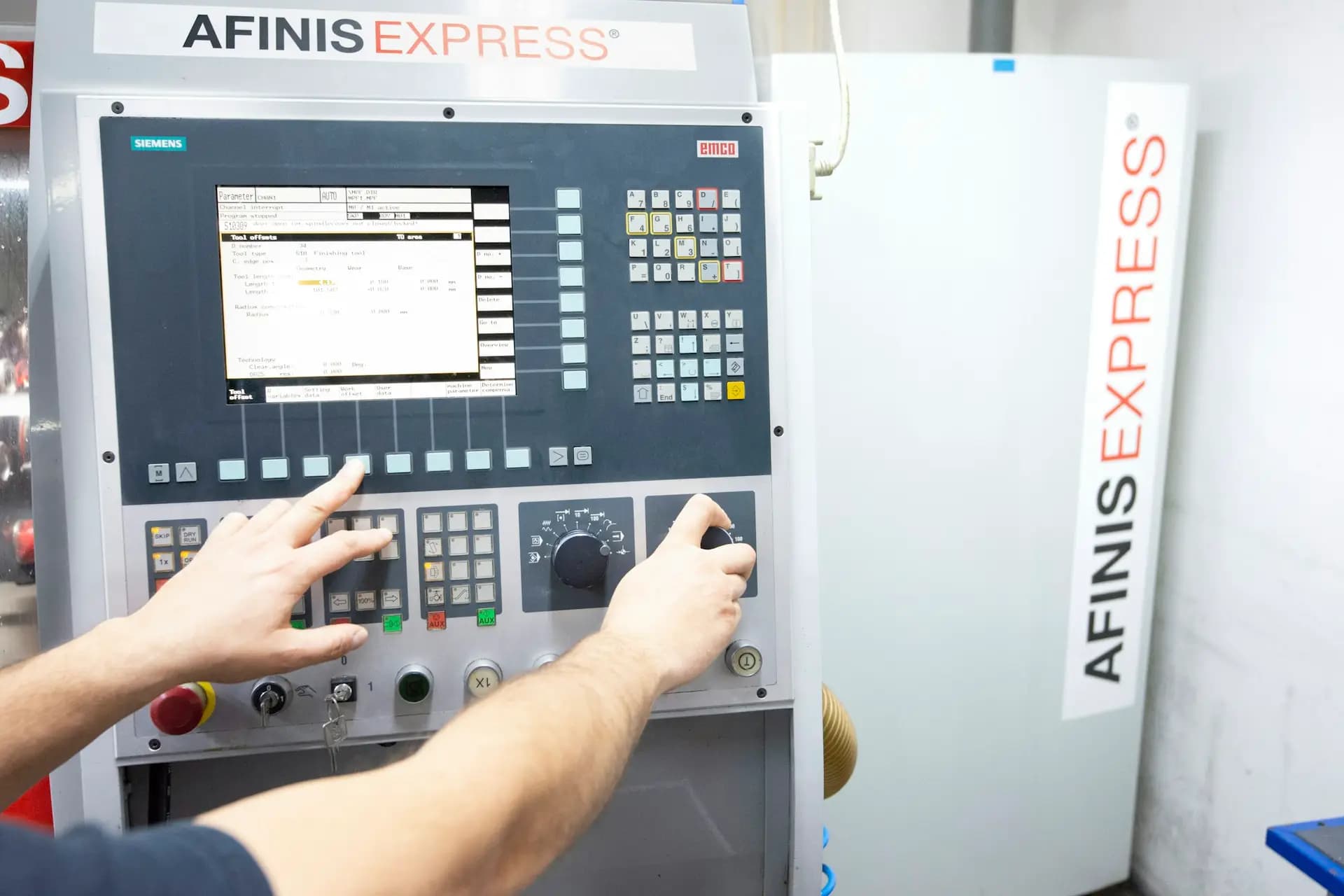 Operator using a machine control panel and screen