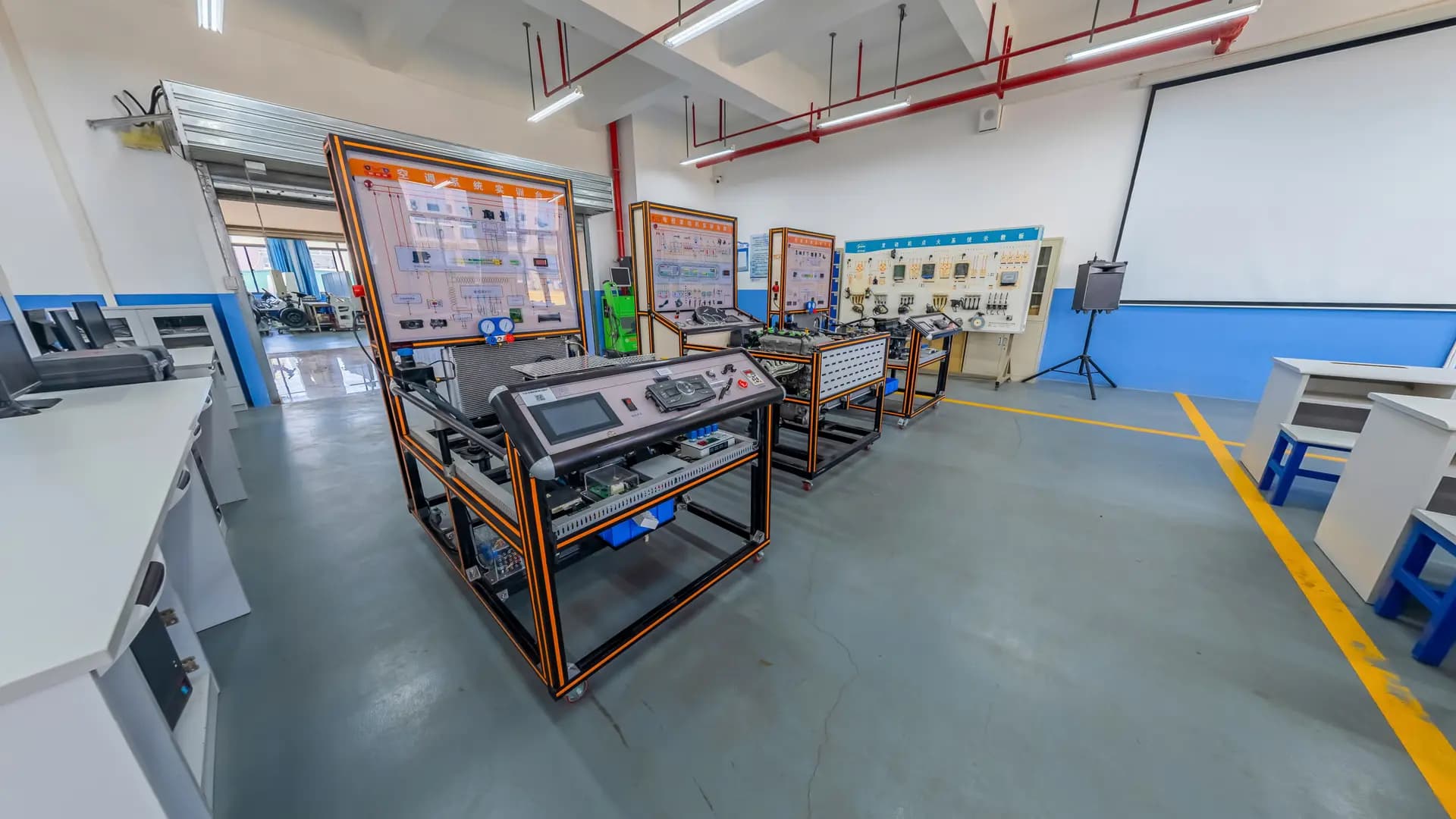 Training lab with industrial control trainer rigs and benches arranged along the floor