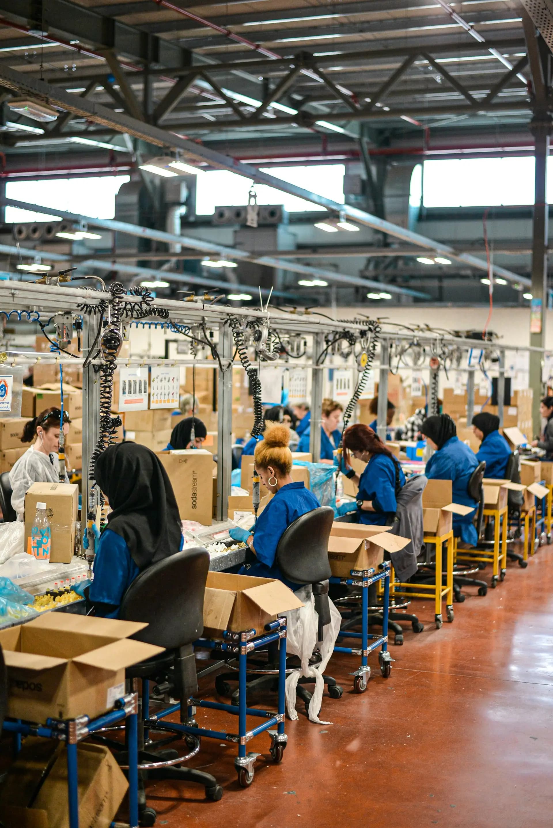 Workers on a busy production line in a large factory