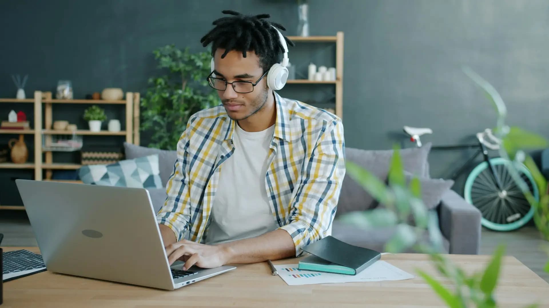 Learner with headphones studying on a laptop at home