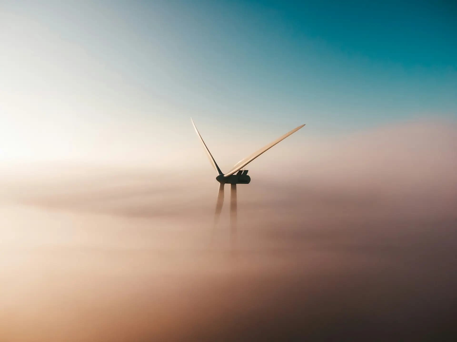 Offshore wind turbine rising from sea mist