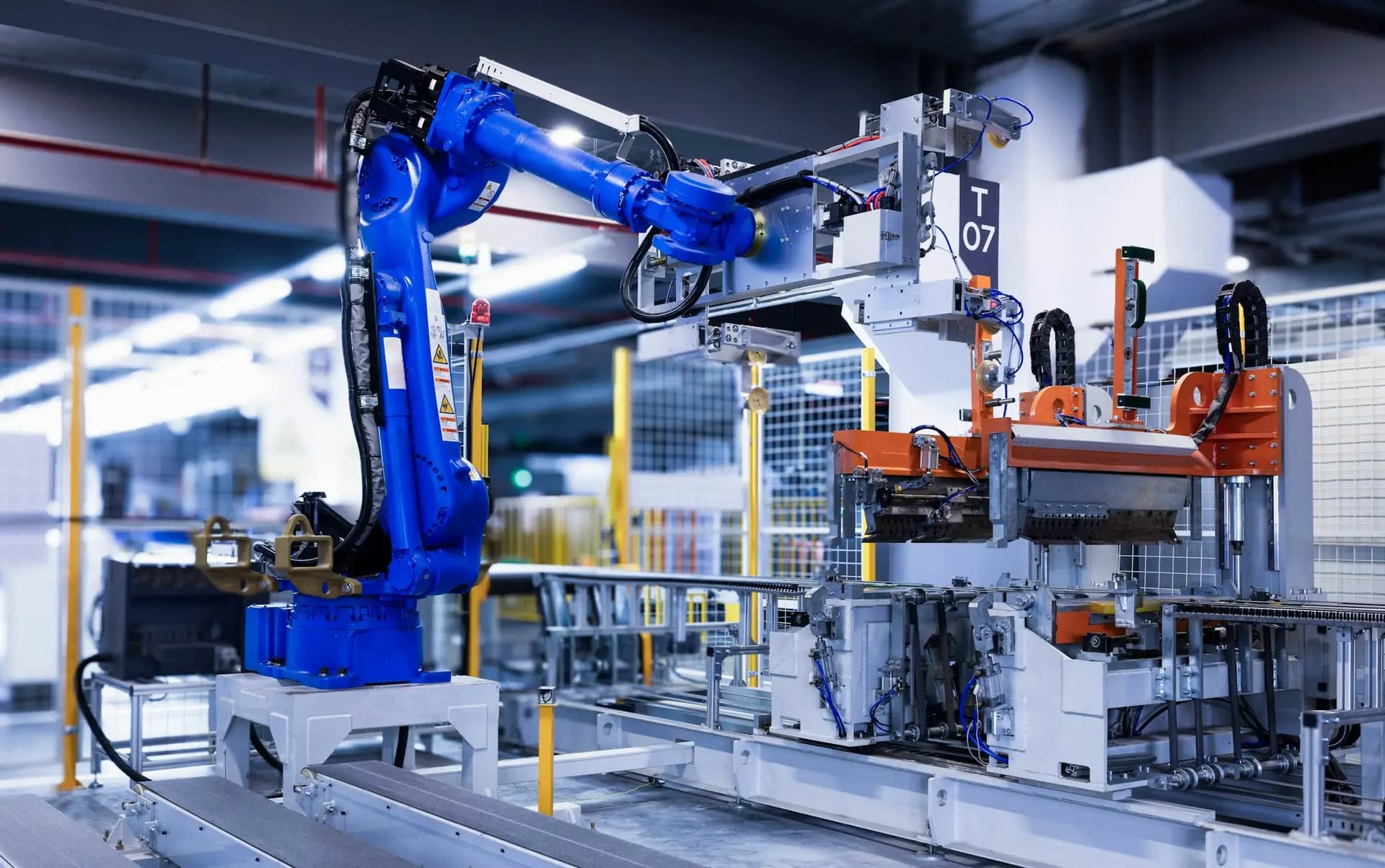 Blue industrial robot arm working in an automated cell