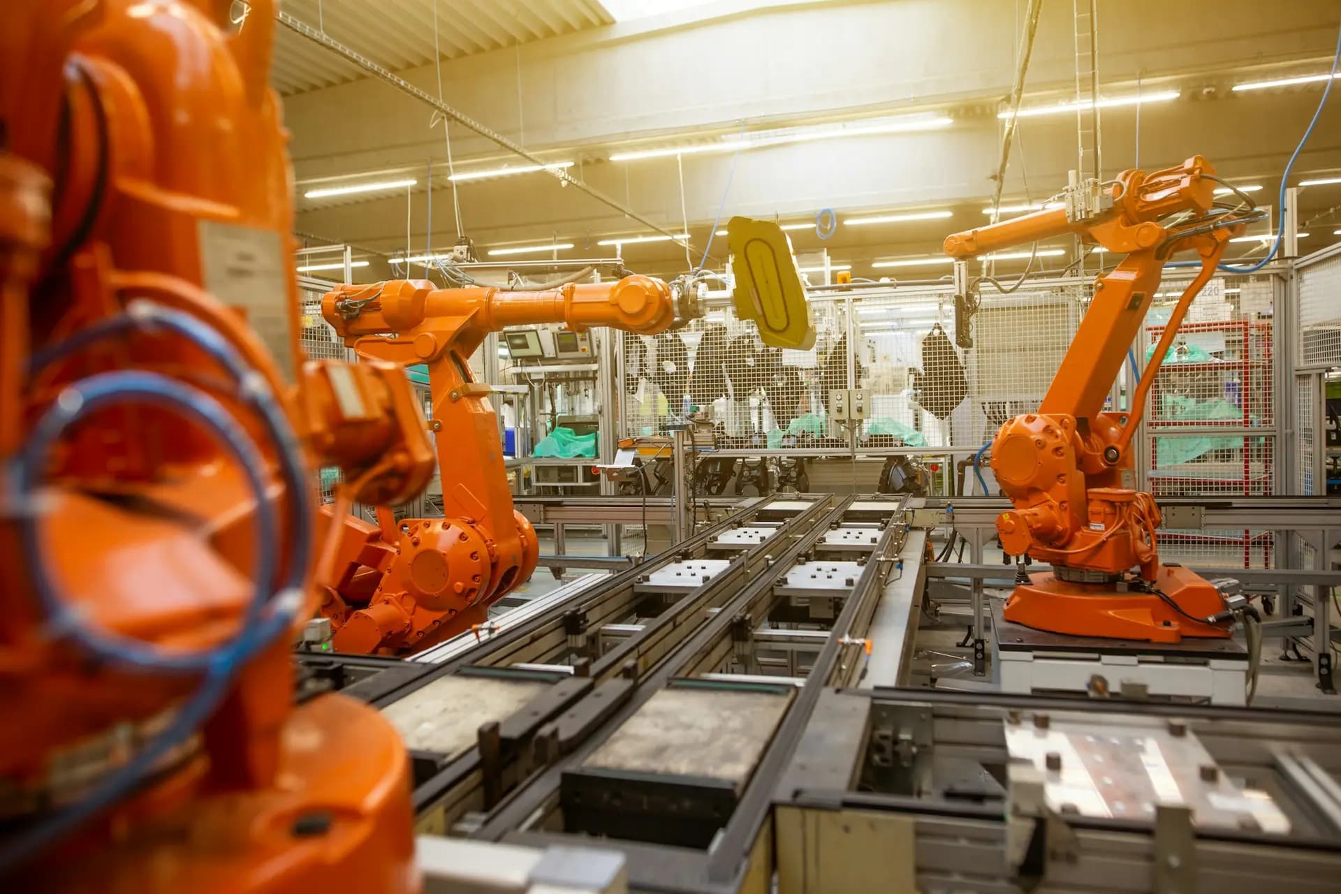 Orange industrial robots on an automated production line